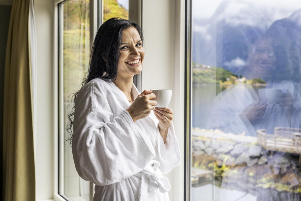 Hotel guest enjoys morning coffee and the view from the room.